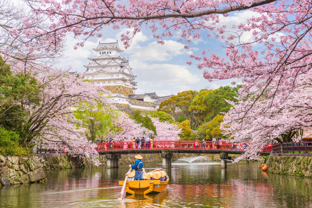 Gente en una lancha admirando el Castillo Himeji en Japón